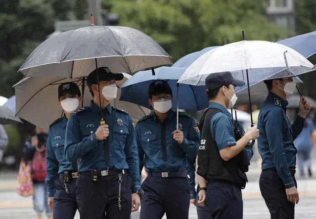 Police officers wearing face masks to help protect against the spread of the coronavirus, walk in downtown Seoul, South Korea, Monday, September 7, 2020. (Photo by Lee Jin-man/AP Photo)