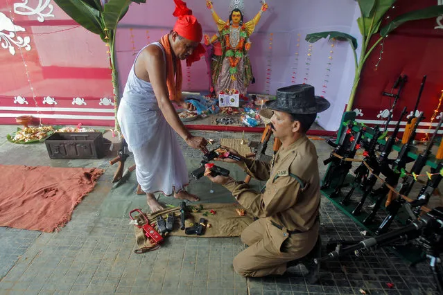 A police officer has weapons blessed by a Hindu priest during the Vishwakarma Puja festival in the outskirts of Agartala, India, September 17, 2016. (Photo by Jayanta Dey/Reuters)