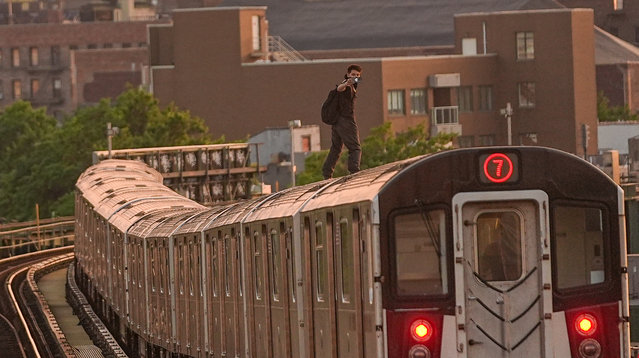 A subway surfer is seen on the roof of a 7 train car on July 10, 2025, in Queens, New York City, United States. Despite a joint campaign between MTA, NYC Public Schools, and Pro BMX Athlete Partner to combat subway surfing, which announced in June by New York Governor Kathy Hochul, it persists among some young people who cannot see the deadly side of surfing because of the viral trends on social media and surfers' social media obsessions. (Photo by Selcuk Acar/Anadolu via Getty Images)