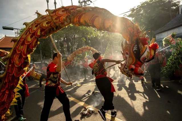 Balis Chinese community perform the dragon dance during Chinese New Year called Ngelawang ceremony on January 21, 2023 in Kuta, Bali, Indonesia. The Chinese diaspora of Southeast Asia is celebrating Lunar New Year, as COVID-19 restrictions have been removed, it is traditionally a time for people to meet their relatives and take part in celebrations with families. In Indonesia, ethnic Chinese families visited temples to celebrate the Year of the Rabbit on January 22. The Chinese community in Bali observes Chinese New Year in accordance with Balinese customs. In multiculturalism, the Balis-Chinese community believes that the performance of the dragon dance, the lion dance called Barong Sai, and offerings to the unseen world will safeguard the community from calamity and balance between the seen and unseen world. (Photo by Agung Parameswara/Getty Images)