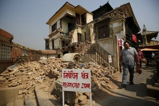 A man walks past the collapsed monastery at the Swoyambhunath Stupa, a UNESCO world heritage site a year after the 2015 earthquakes in Kathmandu, Nepal, April 25, 2016. (Photo by Navesh Chitrakar/Reuters)