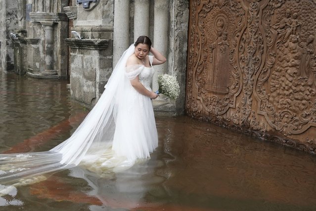 Bride Jamaica Agular prepares to enter the flooded Barasoain church for her wedding in Malolos, Bulacan province, Philippines on Tuesday, July 22, 2025. (Photo by Aaron Favila/AP Photo)