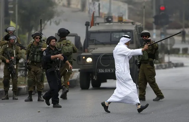 A Palestinian man argues with Israeli soldiers during clashes in the West Bank city of Hebron October 23, 2015. (Photo by Mussa Qawasma/Reuters)