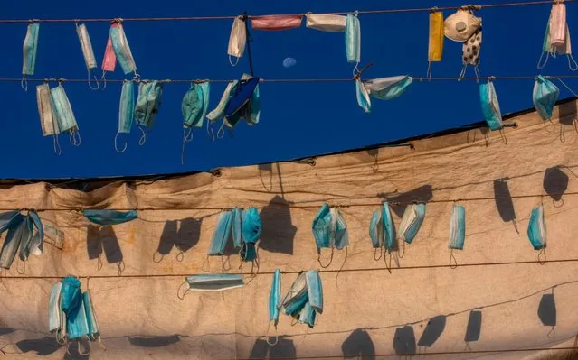 Face masks hang on a boat during a nationwide lockdown to curb the spread of the coronavirus, at the port in the mixed Arab Jewish city of Jaffa, near Tel Aviv, Israel, Wednesday, October 7, 2020. (Photo by Oded Balilty/AP Photo)
