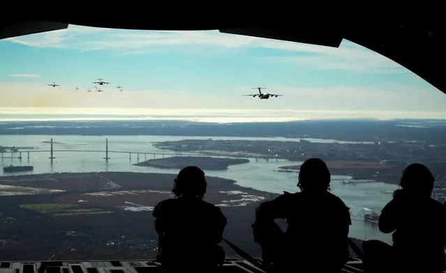 U.S. Air Force Airmen, assigned to the 14th Airlift Squadron watch as 24 C-17 Globemaster III aircraft fly over the Arthur Ravenel, Jr. Bridge, Charleston, South Carolina, January 5, 2023. A formation of 24 C-17 aircraft took flight from JB Charleston to fly over the Arthur Ravenal Jr. Bridge before splitting into four smaller formations to rehearse flexible and deterrent response options, like the ability to land in austere environments and quickly accomplish a variety of mission sets. (Photo by Shellby Matullo/U.S. Air Force/Capture Media Agency)