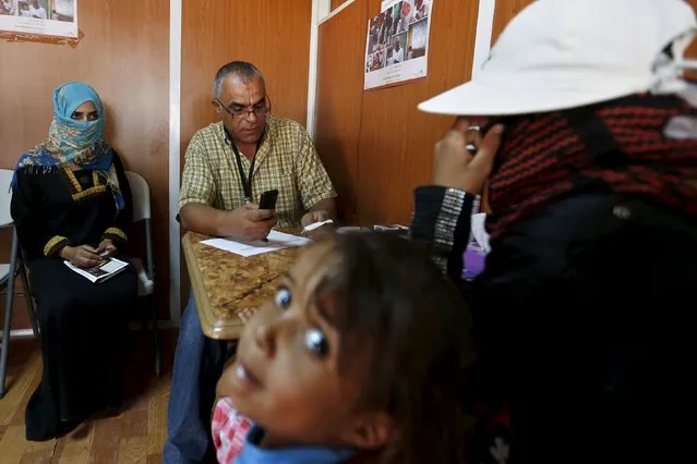 Syrian refugees call their relatives at a centre of the International Committee of The Red Cross, which conducts a programme that enables refugees to get in touch with their relatives either by using mobile phones or by writing letters, during a visit by the Swiss Foreign Minister Didier Burkhalter to the Azraq refugee camp near Al Azraq city, Jordan, October 19, 2015. (Photo by Muhammad Hamed/Reuters)