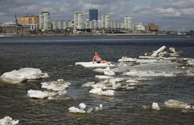 Vladimir Samsonov, 59, a resident from the Siberian town of Zheleznogorsk and a member of the Cryophil winter swimmers club, sunbathes as he sits on an ice floe on the Yenisei River in Krasnoyarsk, Russia, on April 26, 2013. (Photo by Ilya Naymushin/Reuters)