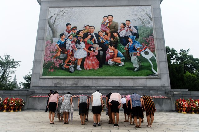 People bow as they visit a mosaic of late North Korean leaders Kim Il Sung and Kim Jong Il in Pyongyang on September 9, 2025, as North Korea marks its 77th founding anniversary. (Photo by Kim Won Jin/AFP Photo)