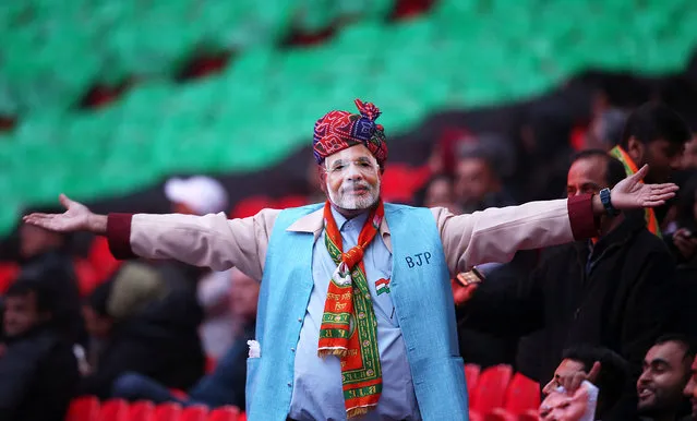 A man wearing a mask depicting Narendra Modi waves at Wembley Stadium prior to the Indian Prime Minister speaking, during the second day of an official three day visit on November 13, 2015 in London, England. Around 60,000 people including British Indians from 450 different community groups from around the country are expected to fill the stadium. (Photo by Dan Kitwood/Getty Images)