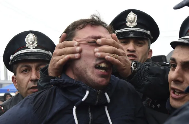 A policeman holds the face of a participant as people protest against the appointment of ex-president Serzh Sarksyan as the new prime minister and demand an early parliamentary election in Yerevan, Armenia April 21, 2018. (Photo by Vahram Baghdasaryan/Reuters/Photolure)