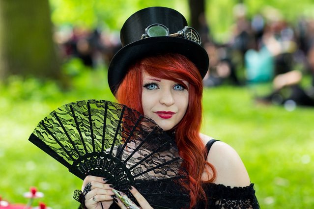 A girl with a fan attends the traditional park picnic on the first day of the annual Wave-Gotik Treffen, or Wave and Goth Festival, on May 17, 2013 in Leipzig, Germany. The four-day festival, in which elaborate fashion is a must, brings together over 20,000 Wave, Goth and steam punk enthusiasts from all over the world for concerts, readings, films, a Middle Ages market and workshops. (Photo by Marco Prosch)