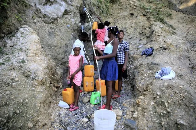 People, without running water at home, collect water from a ravine in Port-au-Prince, Haiti, March 21, 2023. (Photo by Odelyn Joseph/AP Photo)