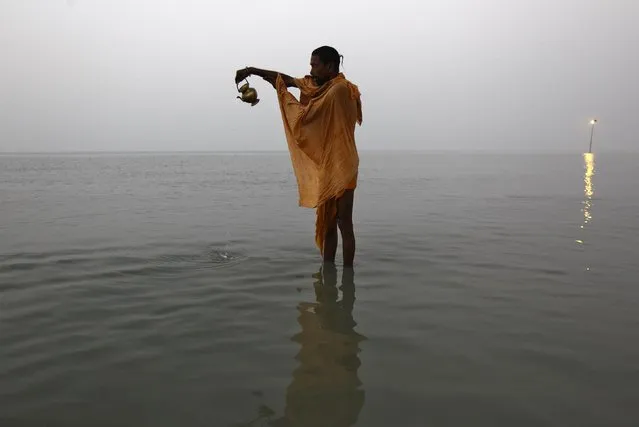 A “Sadhu”, or a Hindu holy man, offers prayers after taking a dip at the confluence of the river Ganges and the Bay of Bengal, ahead of the Makar Sankranti festival at Sagar Island, south of Kolkata January 13, 2015. (Photo by Rupak De Chowdhuri/Reuters)