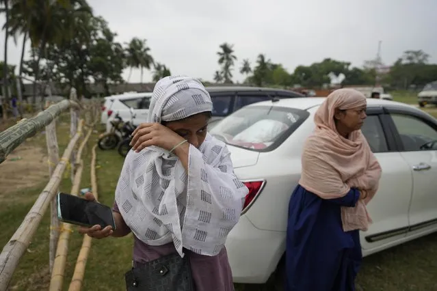 Amina, cries while showing photo of her relative Mohammed Mazar who was traveling in the train that derailed while looking for him at the site of the accident, in Balasore district, in the eastern Indian state of Orissa, Sunday, June 4, 2023. (Photo by Rafiq Maqbool/AP Photo)