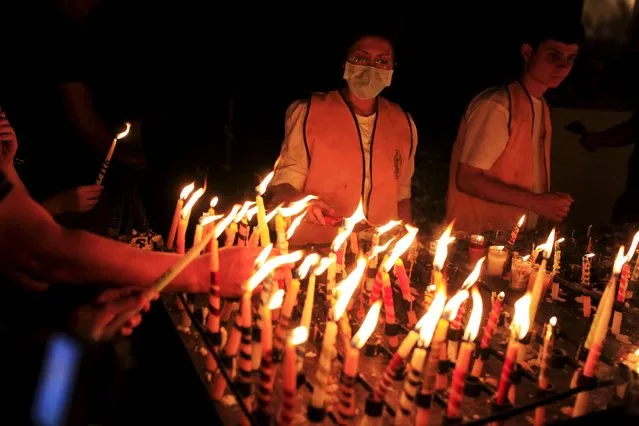 Devotees light candles to celebrate the Day of the Virgin of Guadalupe outside the Basilica of Guadalupe in San Salvador, El Salvador December 11, 2015. (Photo by Jose Cabezas/Reuters)