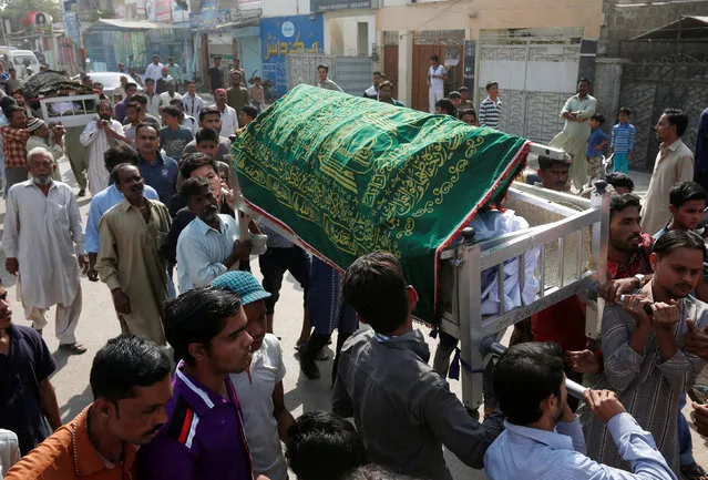 Men carry coffins of relatives, who were killed in an explosion at the Shah Noorani shrine in Baluchistan, during a funeral in Karachi, Pakistan, November 13, 2016. (Photo by Akhtar Soomro/Reuters)