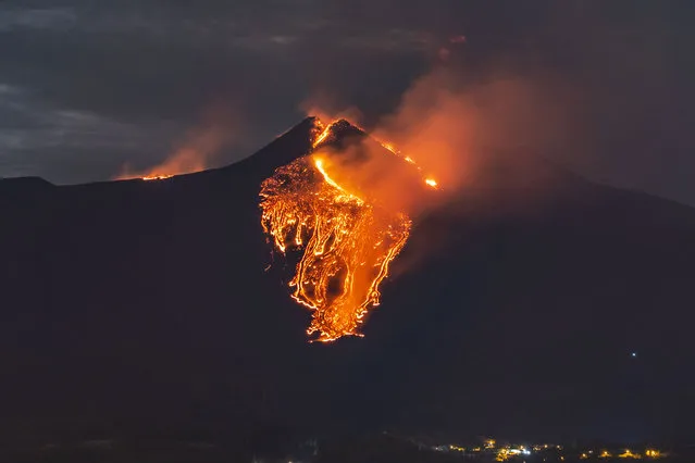 Lava flows from the Mt Etna volcano, near Catania in Sicily, southern Italy, early Tuesday, February 23, 2021. The explosion started before midnight on Monday night, provoking a huge eruption plume that rose for several kilometers from the top of Etna, as reported by The National Institute of Geophysics and Volcanology, Etneo Observatory. (Photo by Salvatore Allegra/AP Photo)