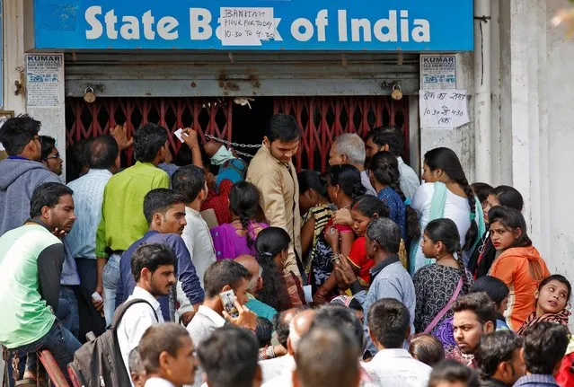 People crowd the entry gate of State bank of India to exchange and deposit their old high denomination banknotes in Lucknow, India, November 15, 2016. (Photo by Pawan Kumar/Reuters)
