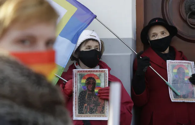 Polish LGBT rights activists gather outside a court which acquitted three women who faced trial on accusations of desecration, in Plock, Poland, Tuesday March 2, 2021.  A Polish court has acquitted three activists who had been accused of desecration for adding the LGBT rainbow to images of a revered Roman Catholic icon. In posters that they put up in protest in their city of Plock, the activists used the rainbow in place of halos on a revered image of the Virgin Mary and baby Jesus. (Photo by Czarek Sokolowski/AP Photo)