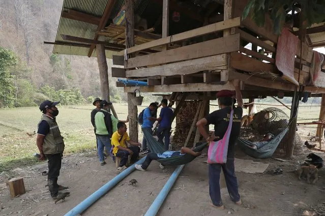 Thai villagers visit a checkpoint of the Thai Rangers in Mae Sakoep village in Mae Hong Son province, Thailand, Monday, March 29, 2021, where people from neighboring Myanmar arrived after they had fled from their homes, following airstrikes by Myanmar's military. (Photo by Sakchai Lalit/AP Photo)