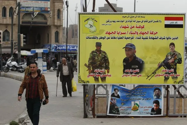 A man walks past a poster, commemorating Shi'ite fighters who were killed in battles with Islamic State militants, at Tahrir Square in Baghdad, Iraq February 7, 2015. Baghdad residents commended a decision by Iraq's Prime Minister Haider al-Abadi to end their city's nightime curfew on Saturday. (Photo by Ahmed Saad/Reuters)