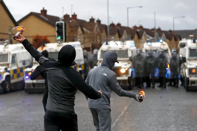 Rioters throw burning bottles at the police on the Springfield Road as protests continue in Belfast, Northern Ireland on April 8, 2021. (Photo by Jason Cairnduff/Reuters)