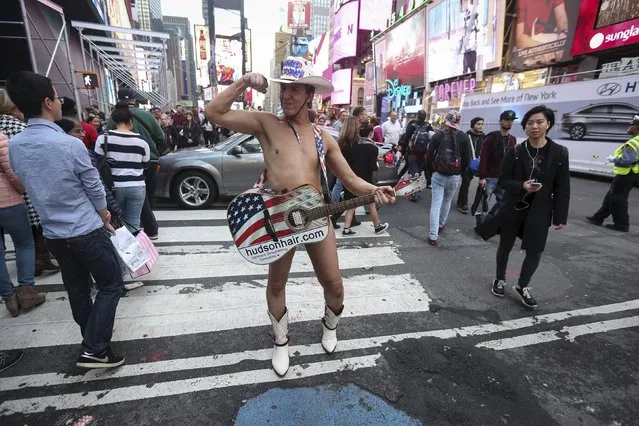 One of the Naked Cowboys poses for photos in Times Square during unseasonably warm weather on Christmas eve in the Manhattan borough of New York, December 24, 2015. (Photo by Carlo Allegri/Reuters)