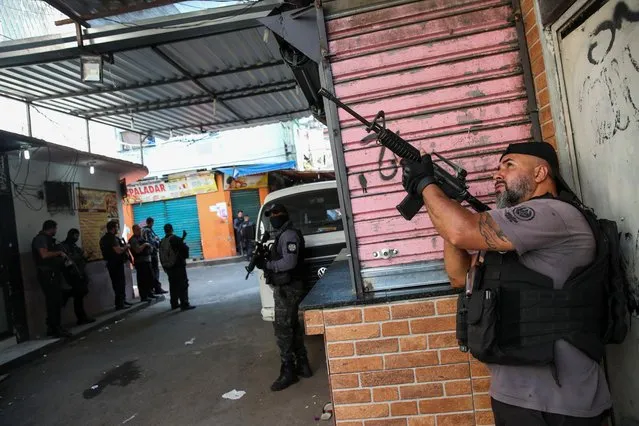 Policemen stand in position during an operation against drug dealers in Jacarezinho slum in Rio de Janeiro, Brazil on May 6, 2021. At least 25 people, including a police officer, were killed in a shootout on Thursday during an operation against drug traffickers in Rio de Janeiro's Jacarezinho slum, police said. (Photo by Ricardo Moraes/Reuters)