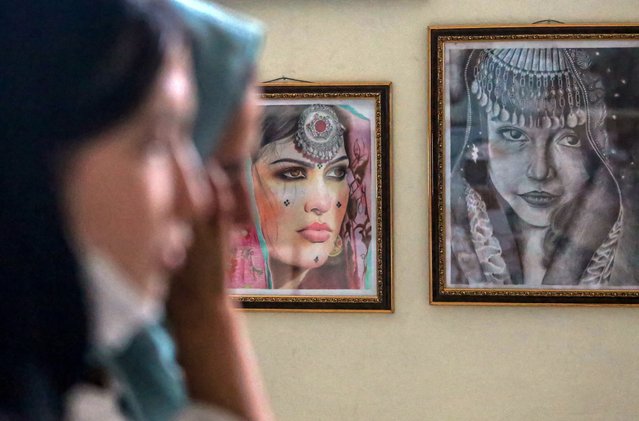 Shakar Rustami (L) and Zulaikha Amini, organizers of the “Smart Way” book and painting exhibition stand in front of painting in Kabul, Afghanistan, 21 August 2023. Young female artists in Kabul held a painting exhibition to express the restrictions imposed by the Taliban on women and girls. The exhibition also featured books displayed by students to promote reading culture. Some of the girls called for the Taliban to lift the restrictions against women and girls. Many female students turned to painting and drawing after schools and universities closed. (Photo by Samiullah Popal/EPA/EFE)