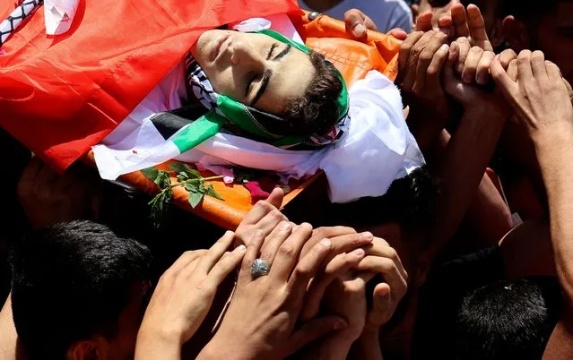 Mourners carry the body of 16-year-old Said Youssef Muhammad Oudeh out of his family home on a stretcher, to begin his funeral procession in the norhern Odla area of the occupied West Bank city of Nablus, on May 6, 2021. The Israeli army shot and killed the Palestinian teenager in the West Bank yesterday, the Palestinian health ministry said. The Israeli army said that Molotov cocktails were thrown at soldiers “during a routine operation south of Nablus”. (Photo by Jaafar Ashtiyeh/AFP Photo)