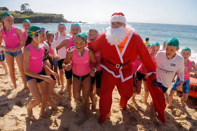 A surf life saver dressed as Santa Claus walks to deliver gifts to children learning to be the next generation of life savers, nicknamed nippers, at Sydney's Coogee beach, Australia, December 11, 2016. (Photo by Jason Reed/Reuters)