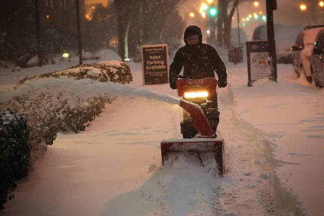A worker clears snow on a sidewalk on January 23, 2016 in Washington, DC. Heavy snow continued to fall in the Mid-Atlantic region causing “life-threatening blizzard conditions” and affecting millions of people. (Photo by Alex Wong/Getty Images)