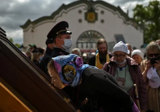 An Orthodox believer kisses the icon of St. Nicholas during a pilgrimage in Kirov Region, Russia on June 3, 2021. (Photo by Alexey Malgavko/Reuters)