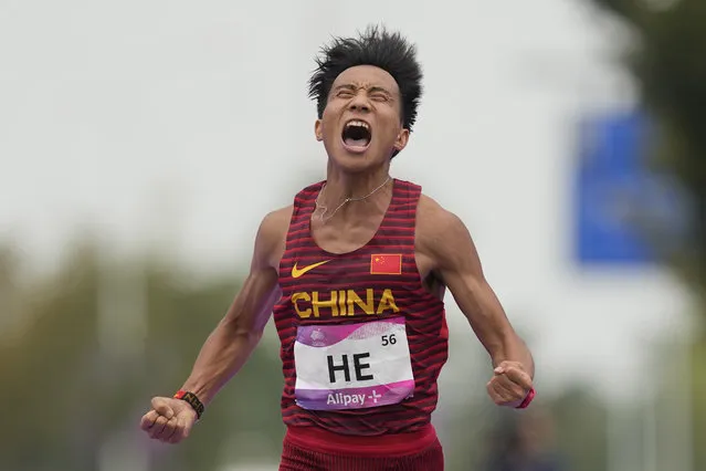 China's He Jie reacts as he crosses the finish line to win the men's marathon at the 19th Asian Games in Hangzhou, China, Thursday, October 5, 2023. (Photo by Lee Jin-man/AP Photo)