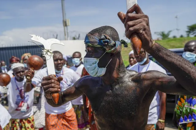Supporters of the former Ivorian president Laurent Gbagbo take part in a traditional dance as they celebrate before his arrival in Abidjan, Ivory Coast, Thursday, June 17, 2021. After nearly a decade, Gbagbo returns to his country after his acquittal on war crimes charges was upheld at the International Criminal Court earlier this year. (Photo by Leo Correa/AP Photo)
