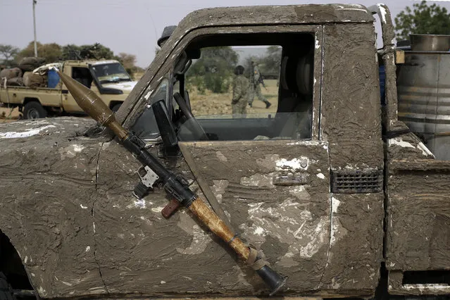 A rocket propelled launcher hangs on the mirror of a camouflaged Chadian pickup truck in the Nigerian city of Damasak, Nigeria, Wednesday, March 18, 2015. Damasak was flushed of Boko Haram militants last week, and is now controlled by a joint Chadian and Nigerien force. (Photo by Jerome Delay/AP Photo)