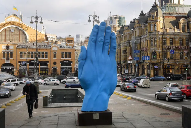 A man passes at the displayed art installation “Middle way” by Romanian artist Bogdan Rata in Kiev, Ukraine, Tuesday, November 20, 2018. The monument set on the central Kiev street of Khreshchatyk, at the place of Vladimir Lenin monument which was destroyed in 2013 during the Maidan events. (Photo by Efrem Lukatsky/AP Photo)