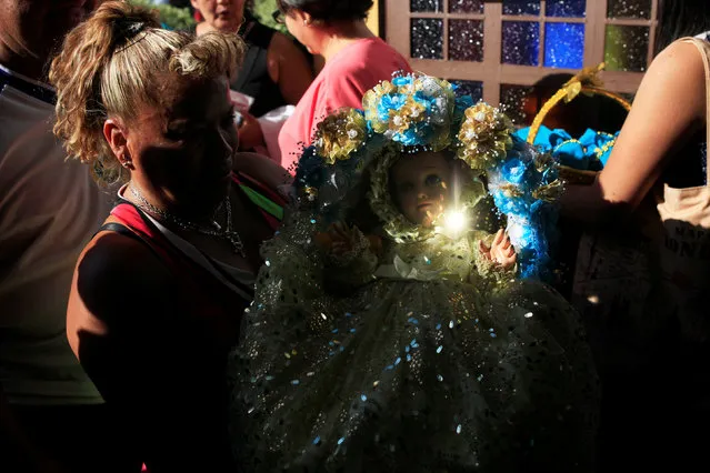 A Catholic faithful holds a figurine of baby Jesus as she waits for a religious procession on Holy Innocents Day in Antiguo Cuscatlan, El Salvador, December 28, 2016. (Photo by Jose Cabezas/Reuters)