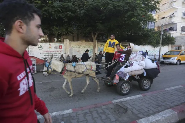 Palestinians ride on a donkey cart in Rafah, Gaza Strip, Thursday, November 16, 2023. (Photo by Hatem Ali/AP Photo)