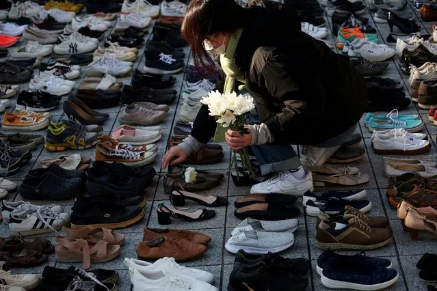 An activist places a floral tribute on a pair of shoes symbolising Palestinians killed, amid the conflict between Israel and Palestinian Islamist group Hamas, during a rally in solidarity of Palestinians in Gaza, in Seoul, South Korea on November 17, 2023. (Photo by Kim Hong-Ji/Reuters)