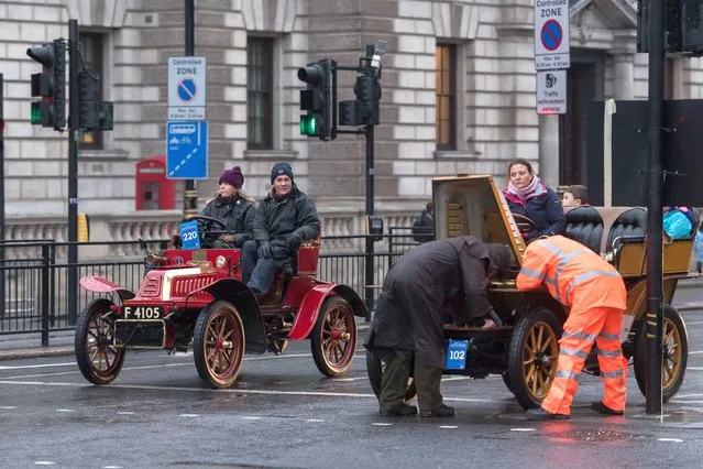 A motorist and RAC mechanic try to fix a broken down vintage car in Whitehall during the RM Sotheby's London to Brighton Veteran Car Run in London, United Kingdom on November 06, 2022. Over 350 vehicles manufactured pre-1905 participate in the event, which is the world's longest running motoring celebration. (Photo by Wiktor Szymanowicz/Anadolu Agency via Getty Images)