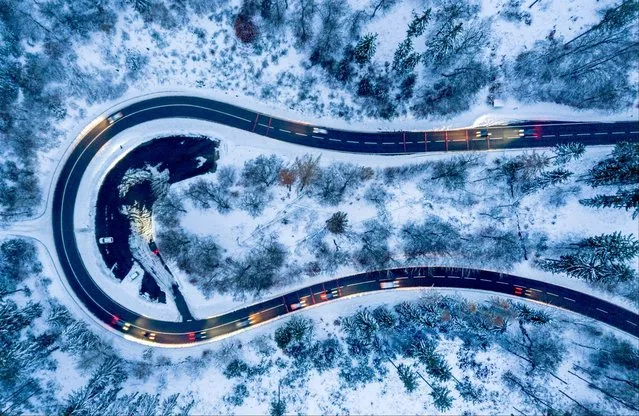 Cars move around a curve in a forest of the Taurus region near Frankfurt, Germany, Friday, December 1, 2023. (Photo by Michael Probst/AP Photo)