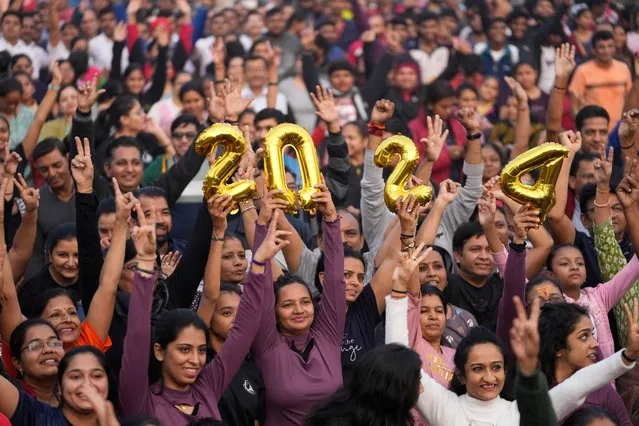 People hold the figure 2024 and cheer during an event to bid good bye to 2023 and welcome the New Year in Ahmedabad, India, Sunday, December 31, 2023. (Photo by Ajit Solanki/AP Photo)