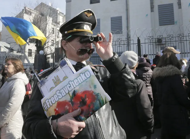 Ukrainians attend a rally to support Ukrainian pilot Nadezhda Savchenko, outside the Russian Embassy in Kiev, Ukraine, Tuesday, March 8, 2016. About 1,000 people rallied at the Russian Embassy to demand that Russia release Ukrainian pilot Nadezhda Savchenko. Savchenko was captured in June 2014 while fighting with a Ukrainian volunteer battalion against Russia-backed rebels in eastern Ukraine. (Photo by Efrem Lukatsky/AP Photo)