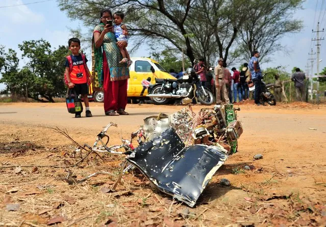 A woman takes photographs of the wreckage after two Hawk aircraft of the Surya Kiran Aerobatic Display Team of the Indian Air Force collided in mid-air while rehearsing ahead of Aero India show at the Yelahanka Air Force Station in Bengaluru, February 19, 2019. (Photo by Reuters/Stringer)