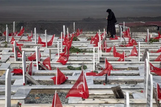 A woman mourns at the grave of a loved one that was killed in last year's earthquake at a cemetery on February 06, 2024 in Hatay, Turkey. In the early hours of February 6, 2023, a 7.8-magnitude earthquake struck southern Turkey, followed by another 7.5-magnitude tremor just after midday. The quakes caused widespread destruction in southern Turkey and northern Syria and has killed more than 50,000 people. (Photo by Chris McGrath/Getty Images)