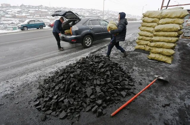 People load coal into a car in Ulaanbaatar, Mongolia as the wave of extreme cold hits the country December 22, 2016. Picture taken December 22, 2016. (Photo by B. Rentsendorj/Reuters)