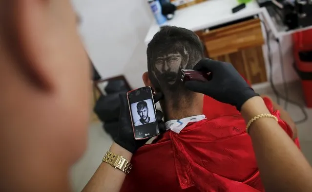 Hair artist and barber Nariko, 27, etches an image of Barcelona's Neymar on the head of customer Luiz Fernadez, 15, before the Champions League semifinal first leg soccer match between Barcelona and Bayern Munich at his barbershop in Sao Vicente, near Santos, in Sao Paulo state May 6, 2015. (Photo by Nacho Doce/Reuters)