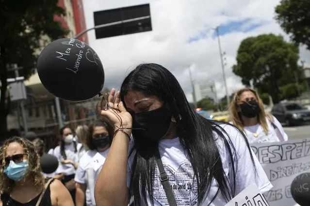 A woman cries during a protest by the “Widows of COVID” group against the way the government handled the nation's response to the new coronavirus pandemic, on the Day of the Dead in Rio de Janeiro, Brazil, Tuesday, November 2, 2021. (Photo by Bruna Prado/AP Photo)