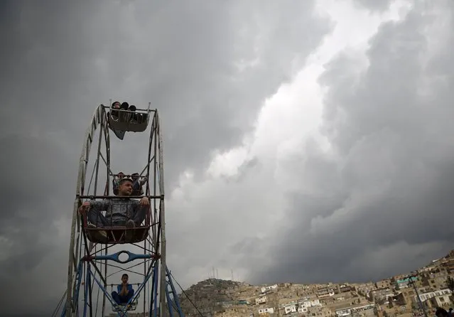 Children ride on a ferris wheel during  the celebration for Afghan New Year (Newroz) in Kabul, Afghanistan March 20, 2016. (Photo by Ahmad Masood/Reuters)
